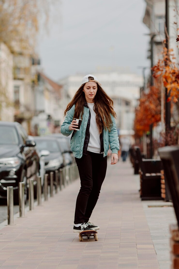 無料Photo スケートに乗っている間コーヒーのカップを保持しているスケートボーダーの女の子