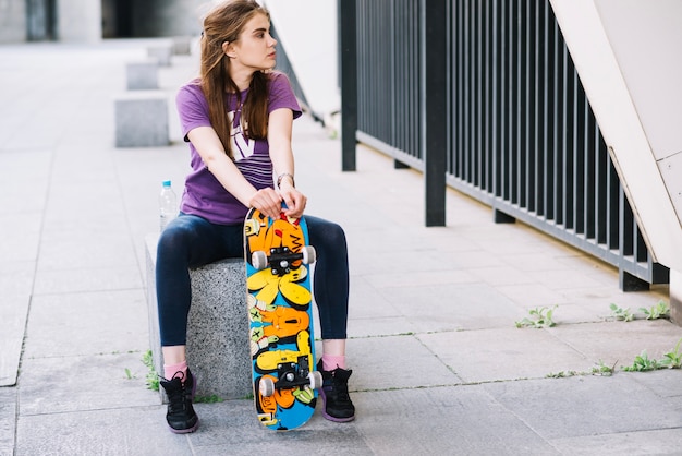 Ragazza skateboarder guarda a sinistra