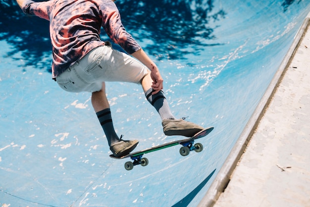 Skateboarder che salta sulla rampa