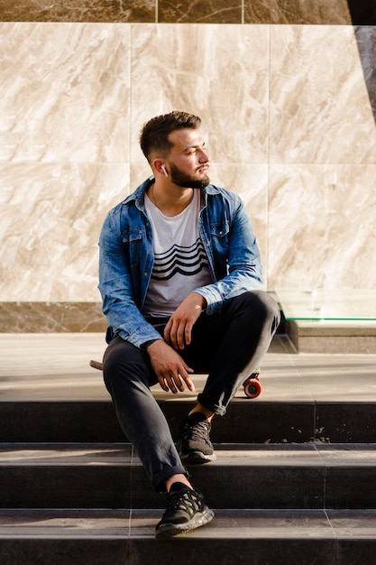 Skateboarder sitting on staircase