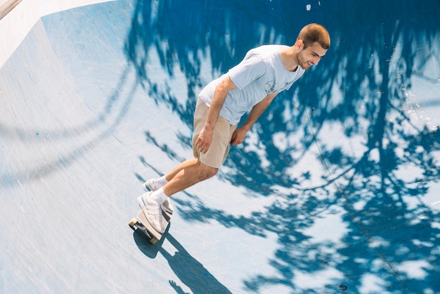 Skateboarder smiling and riding on ramp