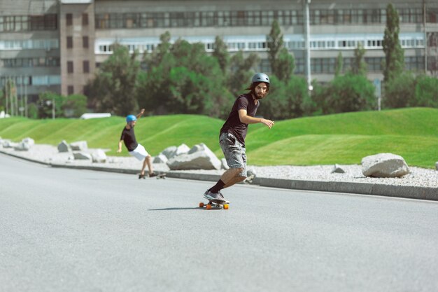 Skateboarders doing a trick at the city's street in sunny day