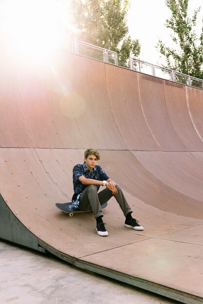 Free photo skater boy sitting in half pipe