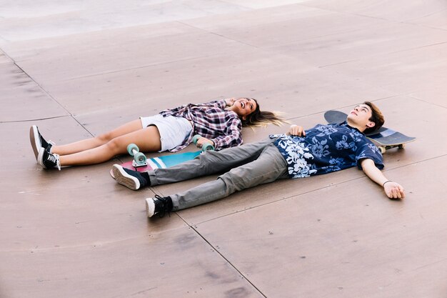 Skater couple lying on ground