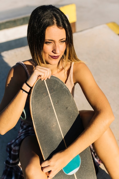 Free photo skater girl holding her board