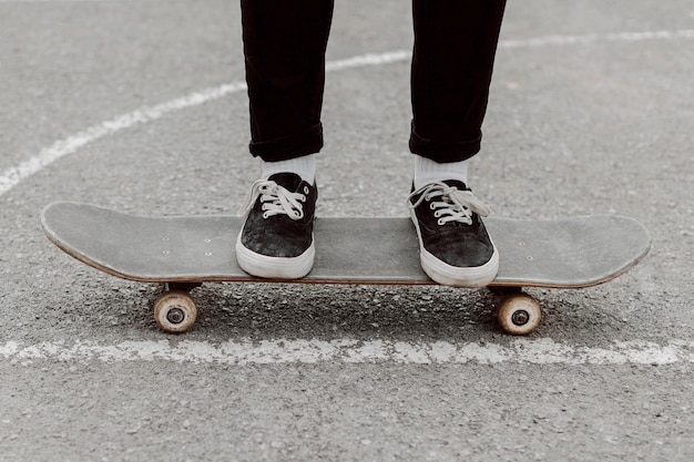 Foto gratuita gambe di ragazza pattinatrice in piedi sul suo skateboard