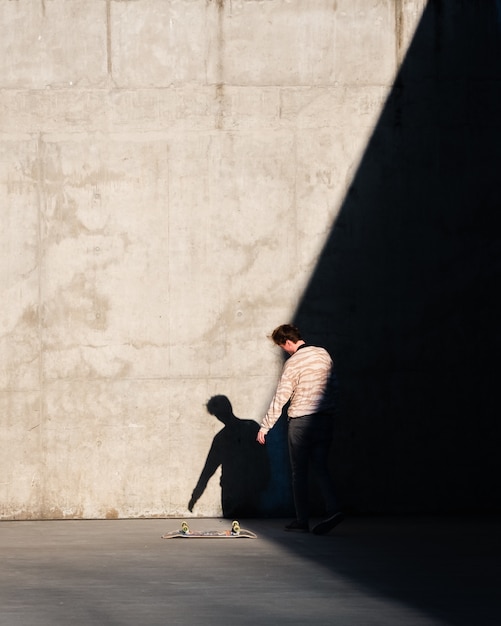 Foto gratuita pattinatore nel parco raccogliendo il suo skate