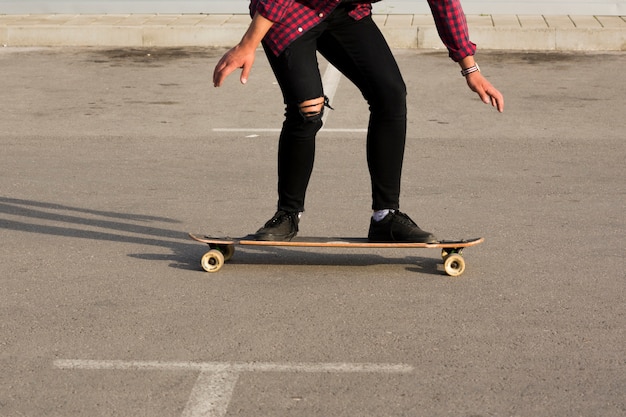 Foto gratuita pattinatore che guida longboard sull'asfalto