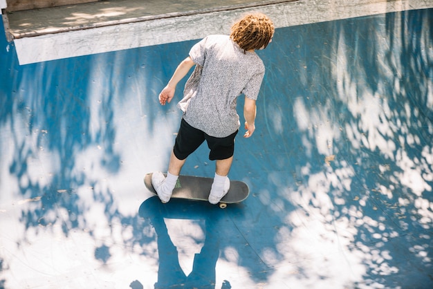 Skater with dreadlocks riding in skatepark