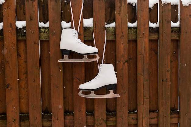 Free photo skates hanging on wooden fence