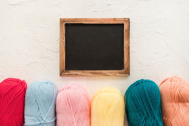 Skeins of yarn near chalkboard