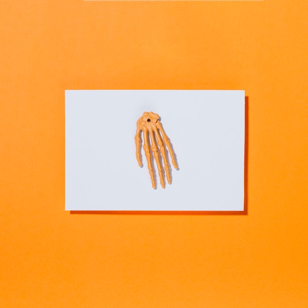 Skeleton bony hand on piece of white paper