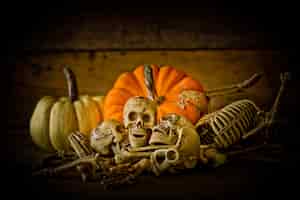 Free photo skeleton and pumpkin on wood ,happy halloween background ,halloween pumpkins