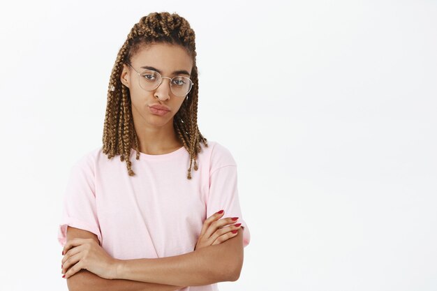 Skeptical african-american female student in glasses looking doubtful and serious