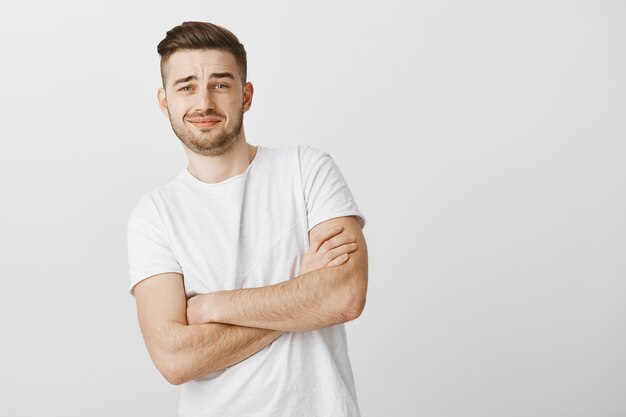 Skeptical bearded guy cross arms and look with scorn at something