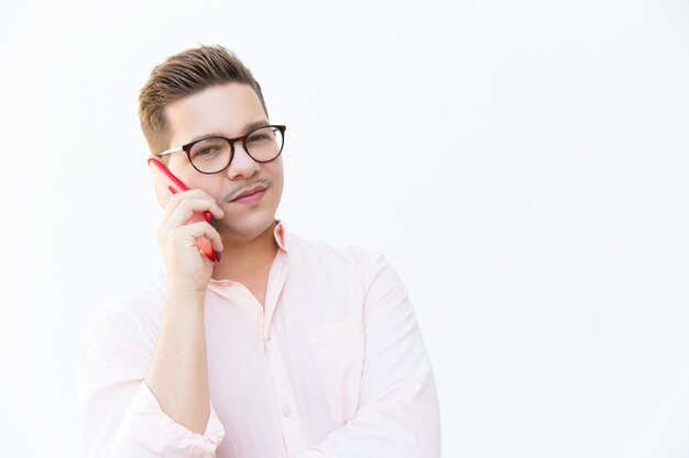 Skeptical guy in eyeglasses speaking on cell