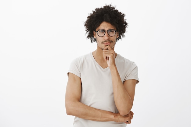 Skeptical thoughtful handsome man in glasses looking , pondering, making choice