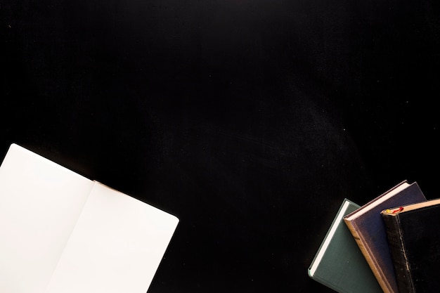 Sketchpad and books on black desk