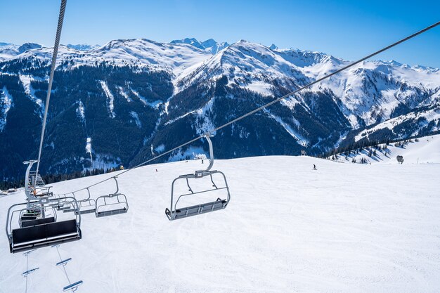 美しい雪に覆われた山々の上のスキーリフトロープウェイ