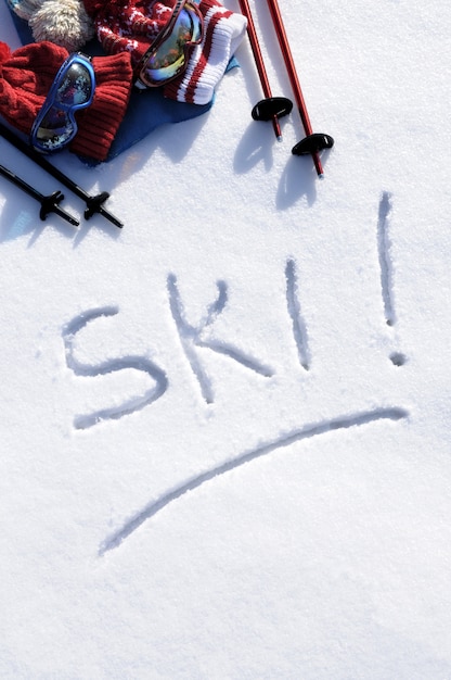 Foto gratuita la parola scritta di sci nella neve con racchette da sci