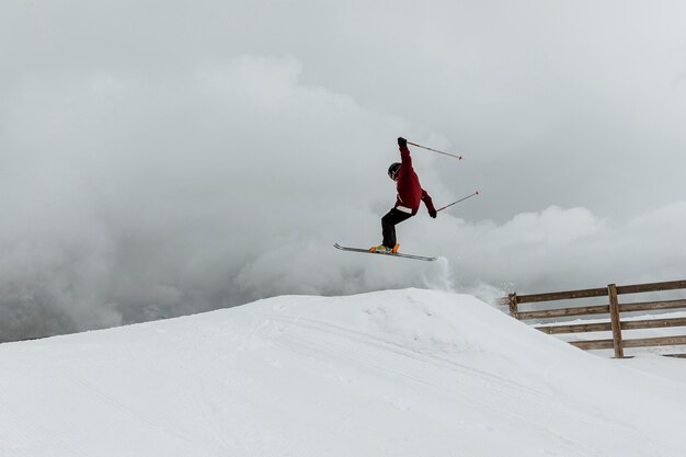 Лыжник прыгает через холм, длинный выстрел