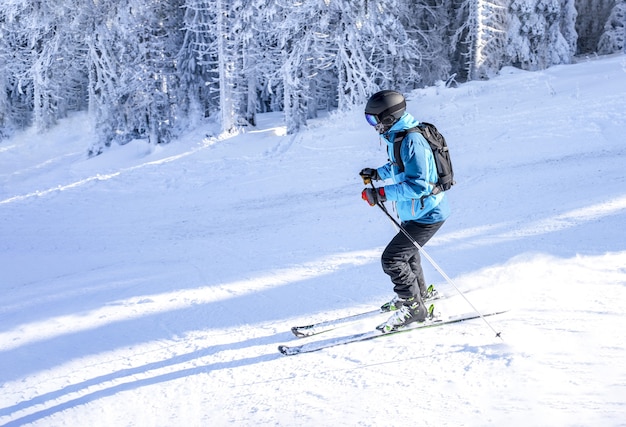 Skier riding downhill in a mountain resort