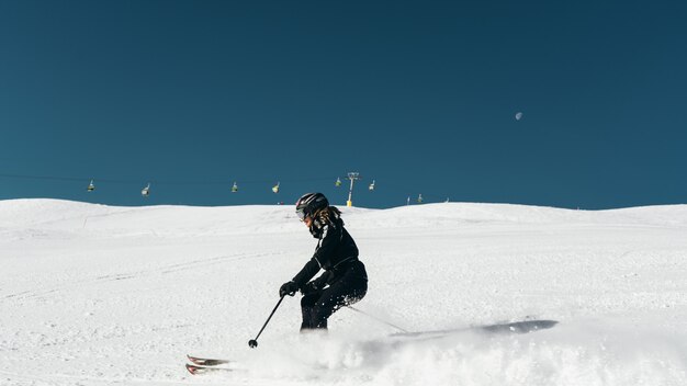 스키 복장과 헬멧을 착용 눈 덮인 표면에 스키 스키