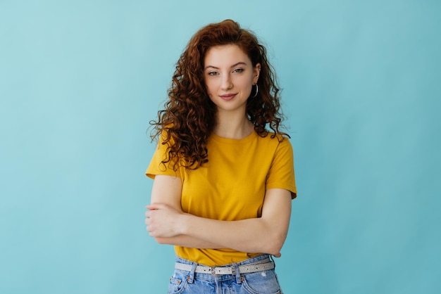 Abile fiducioso allegro sorridente donna rossa con le mani incrociate al petto girando il viso a sinistra divertito interessato professionista libero professionista pronto a mettersi al lavoro