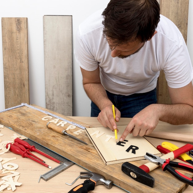 Skilled carpenter worker using his tools on wood