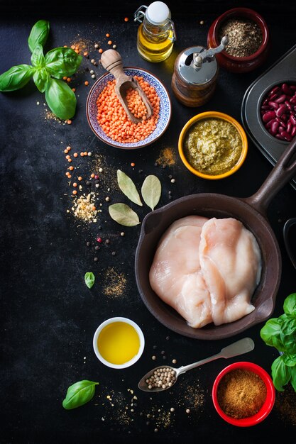 Skillet with chicken fillets and various spices