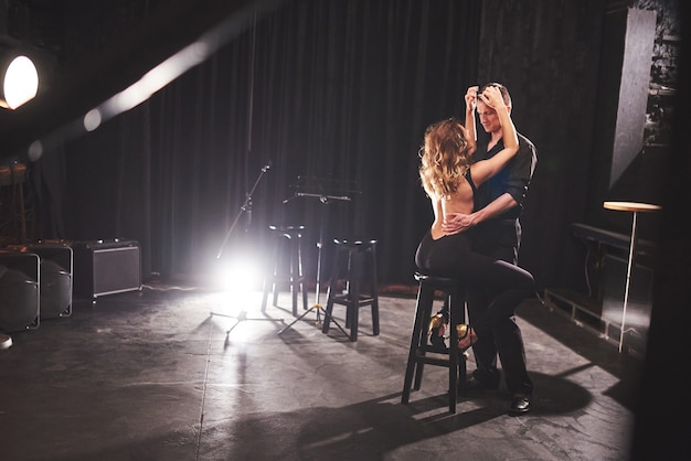 Skillful dancers performing in dark room under light.