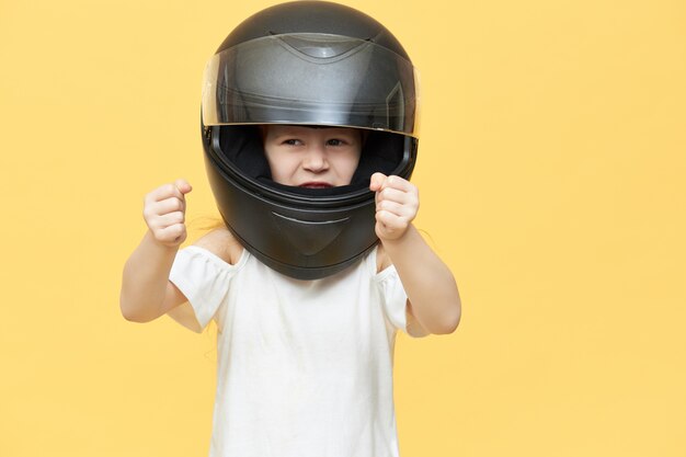 Умелая опытная маленькая девочка в защитном мотоциклетном шлеме