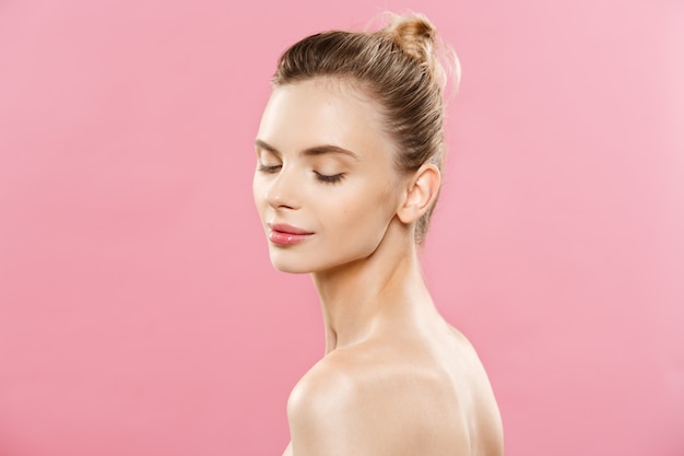 Skin Care Concept - Charming young caucasian woman with perfect makeup photo composition of brunette girl. Isolated on pink background with Copy Space.