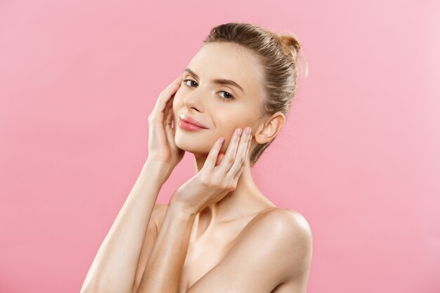 Skin Care Concept - Charming young caucasian woman with perfect makeup photo composition of brunette girl. Isolated on pink background with Copy Space.