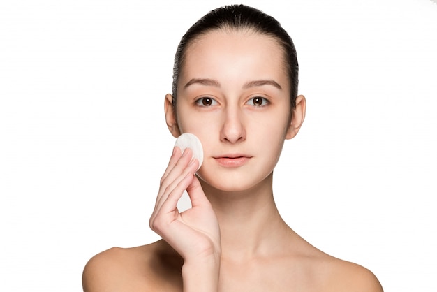 Skin care woman removing face with cotton swab pad