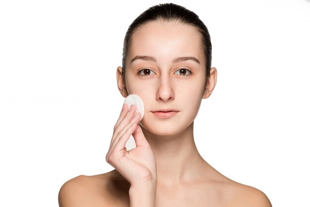 Skin care woman removing face with cotton swab pad