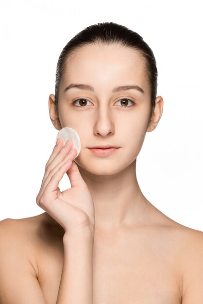 Skin care woman removing face with cotton swab pad