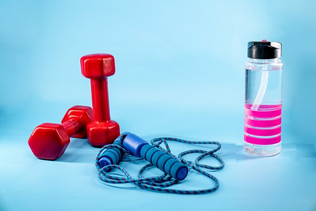 Skipping rope, dumbbells, and bottle of water