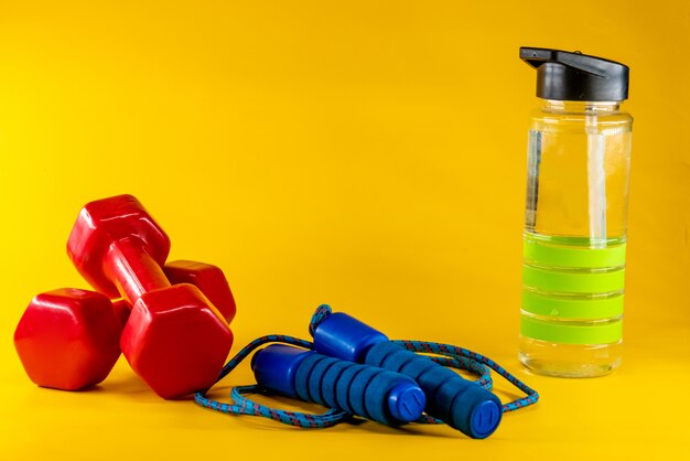 Skipping rope, dumbbells, and bottle of water