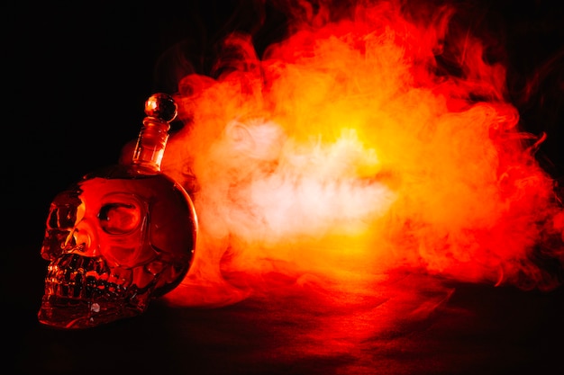 Skull-shaped bottle in red smoke