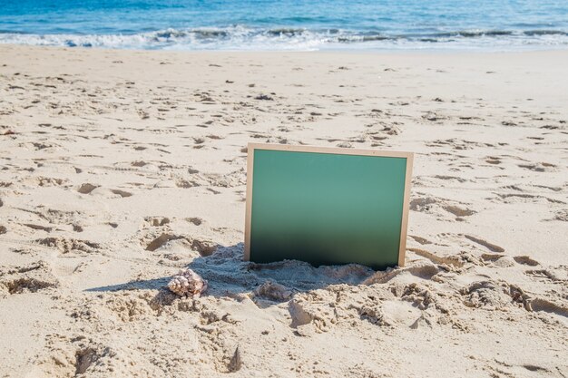 Free photo slate sticking in the sand at the beach