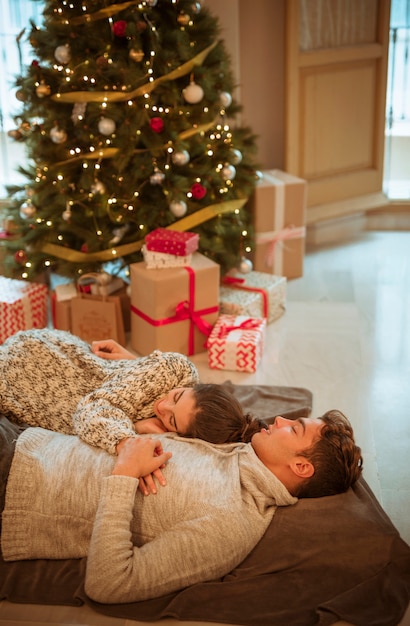 Sleeping couple at Christmas tree 