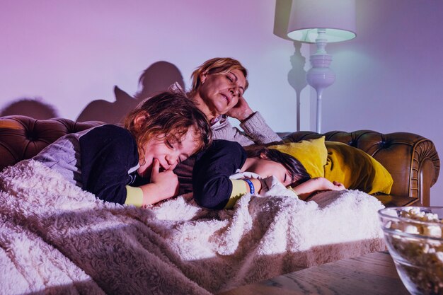 Sleeping kids with mother on couch