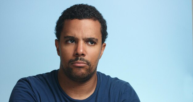 Sleepy mixed race man portrait on a deep blue background