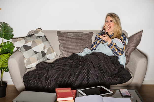 Sleepy mother with baby watching TV