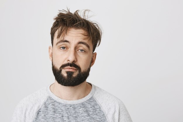 Sleepy tired bearded man looking exhausted with messy hair