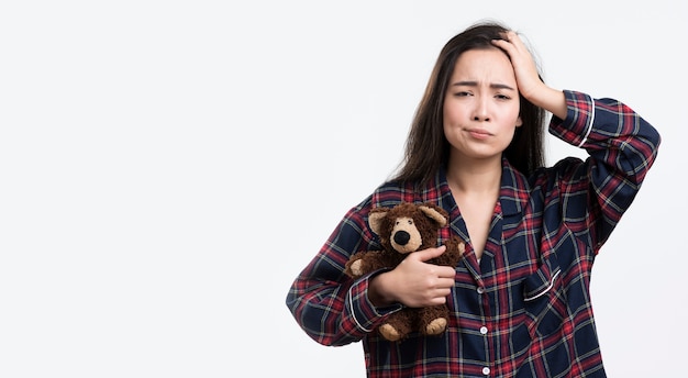 Sleepy woman with teddy bear