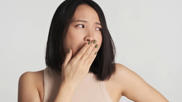 Sleepy woman yawning covering mouth with palm feeling very tired after day at work Female want to sleep isolated on white background