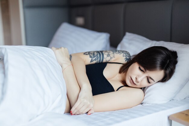 Sleepy Young woman lying in bed doesn't want to wake up