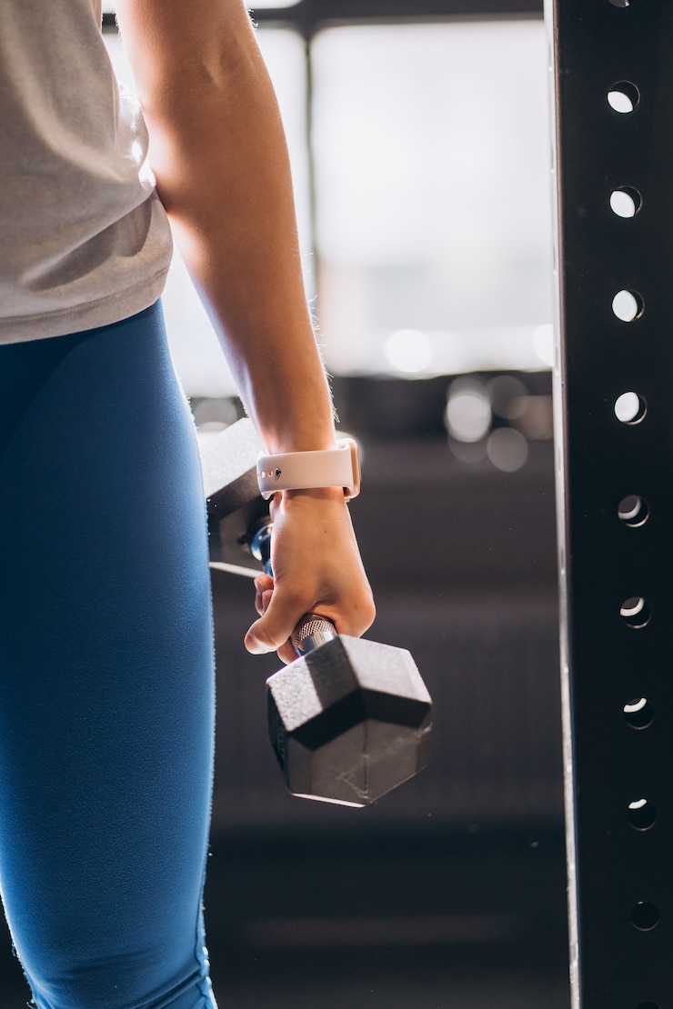 Free Photo slender athletic girl performs physical exercises with dumbbells.